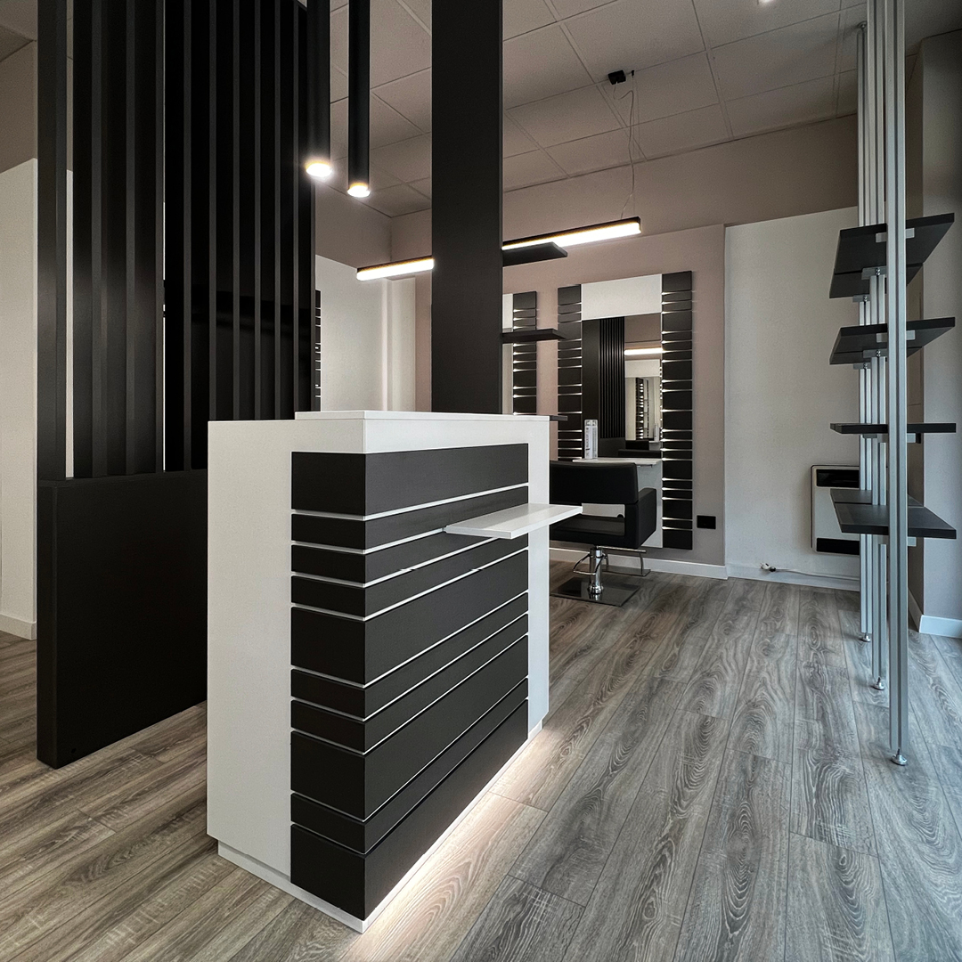 Immagine della reception con bancone bianco a strisce in legno nere